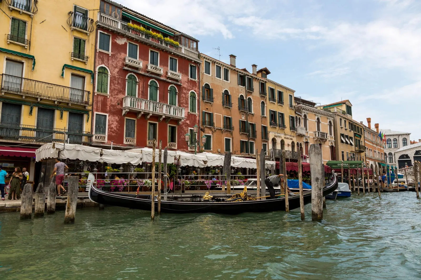 Charming view of gondolas lined up along colorful Venetian buildings on a canal.