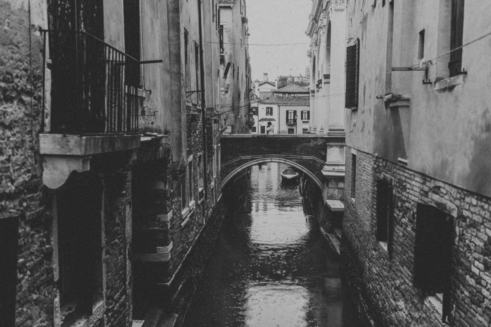 Monochrome view of a canal in Venice with historic architecture.