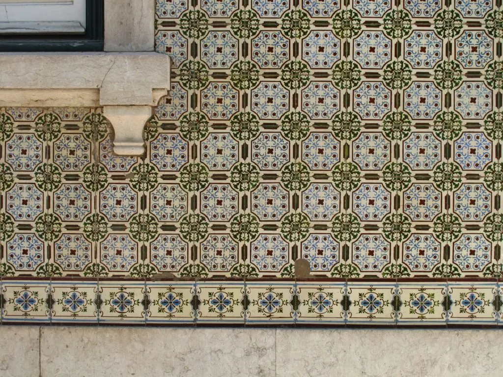 Intricate azulejo tile wall in Lisbon, Portugal displaying traditional Portuguese patterns.