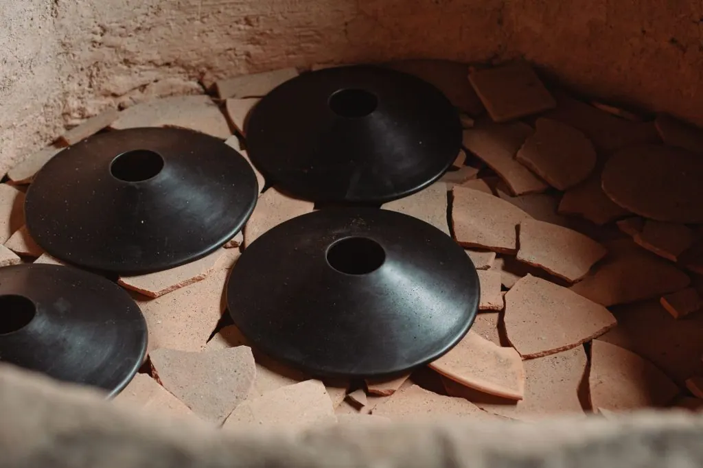 Artisan pottery kiln showcasing traditional craftsmanship with ceramic pieces and shards.