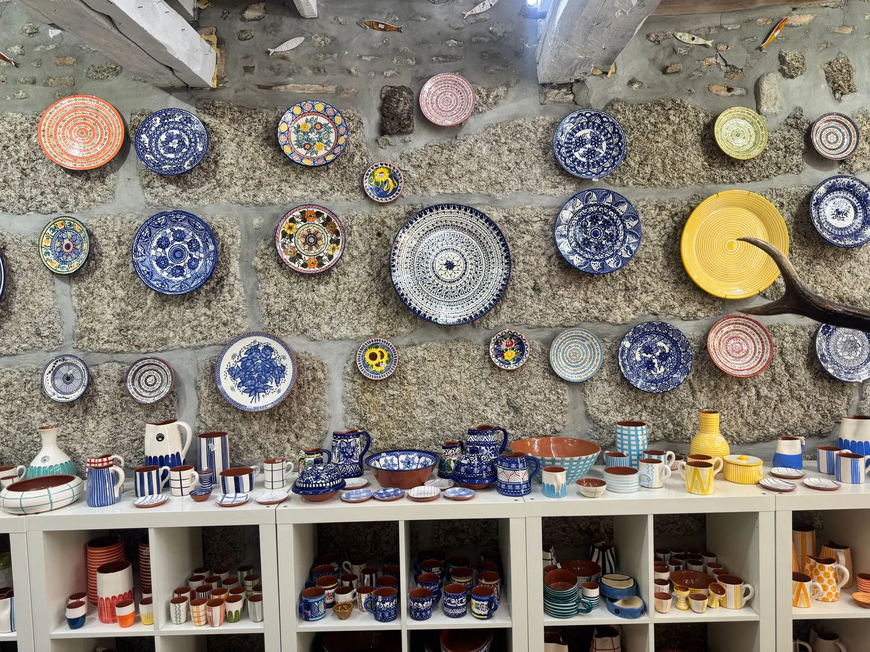 Hand-painted ceramic plates on display in a Portuguese artisan shop