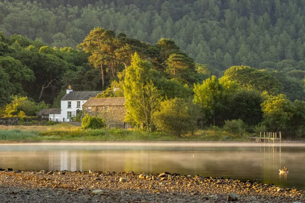 Tranquil rural scene of a lake and house in England's Lake District during summer.