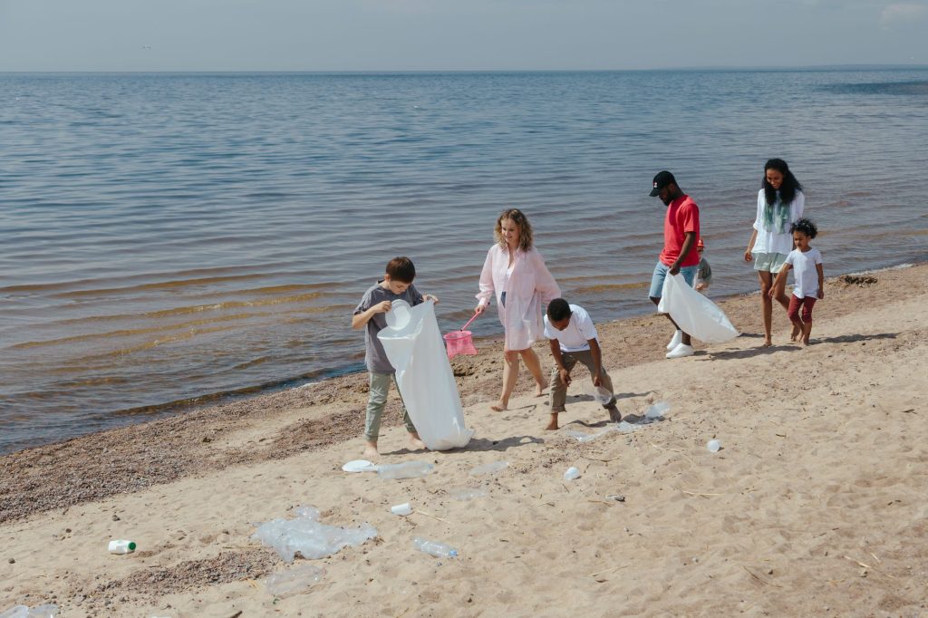 A diverse group of people engaging in beach clean-up, promoting environmental care.