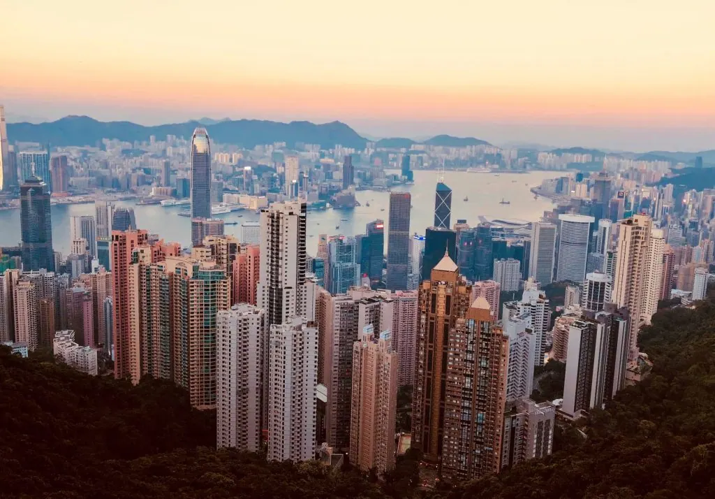 Breathtaking Kowloon skyline with skyscrapers and harbor at sunset, showcasing Hong Kong's urban beauty.