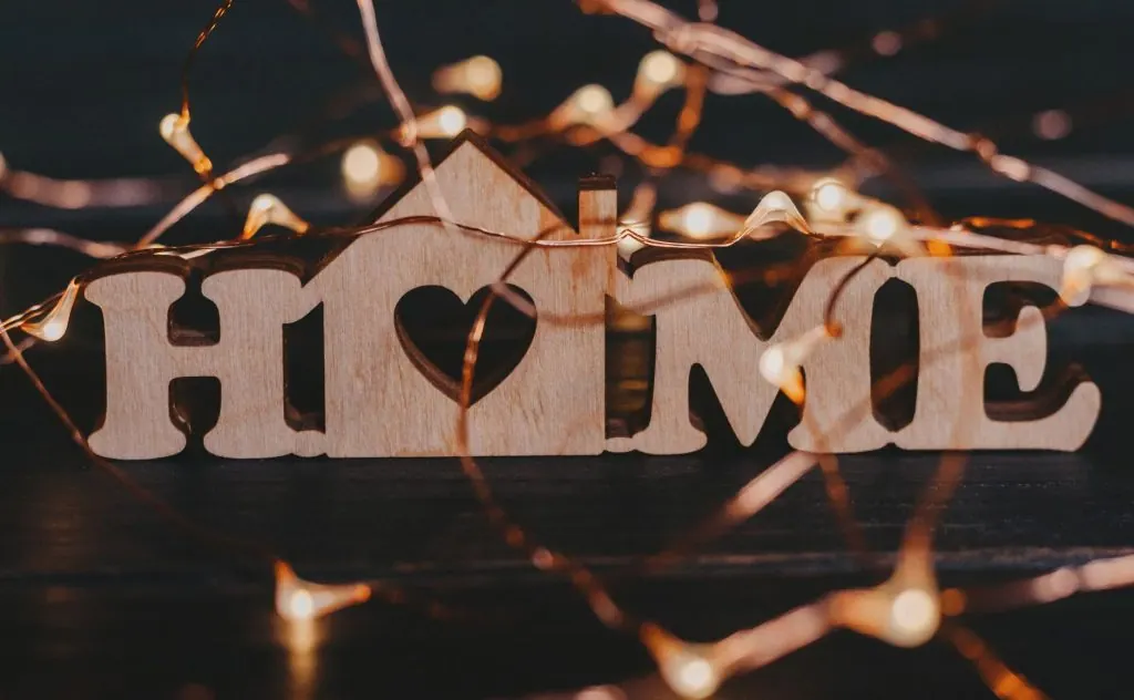 Warm and inviting wooden 'HOME' sign surrounded by glowing fairy lights.