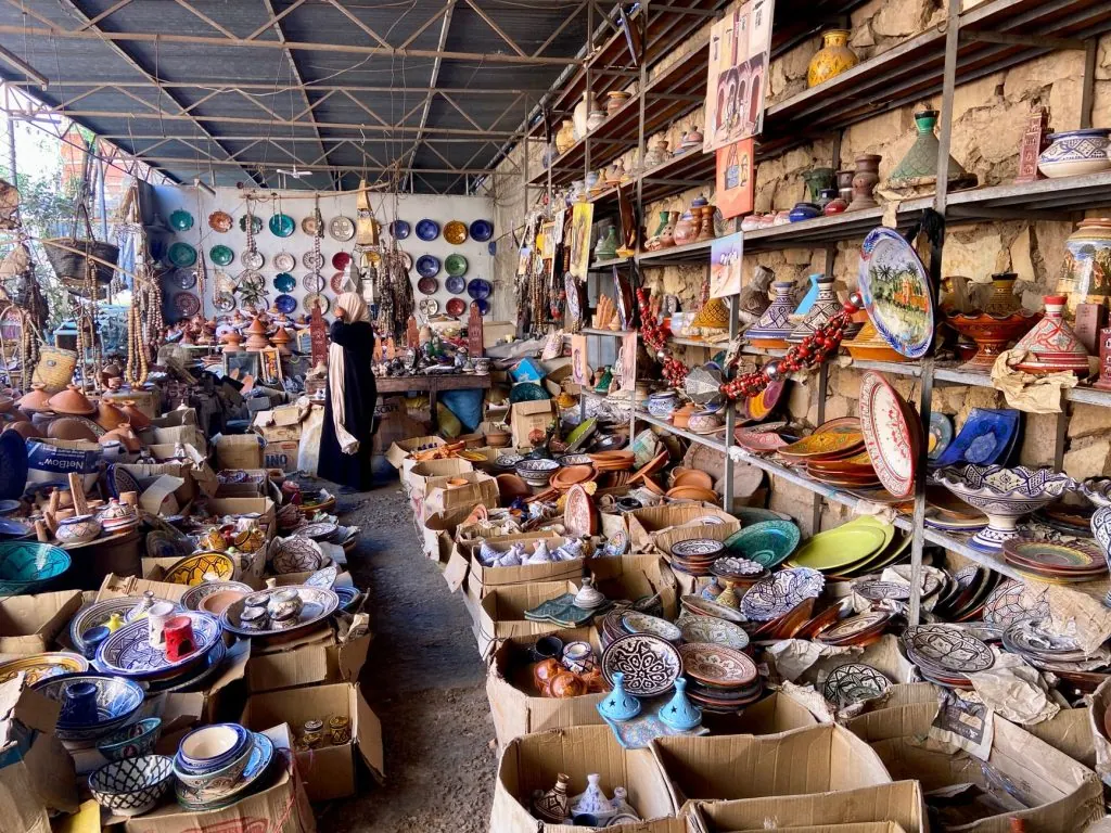 Traditional Moroccan pottery and ceramics displayed in bustling market stall, offering a vibrant cultural experience.