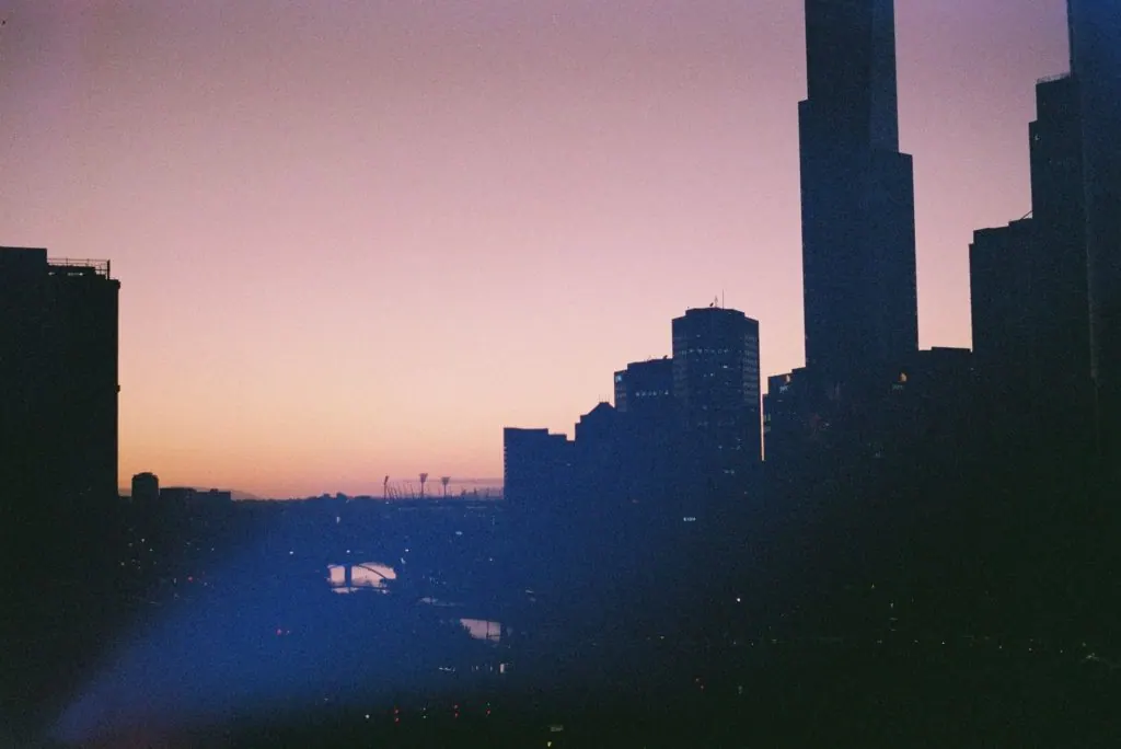 Captivating Melbourne city skyline silhouette during a serene sunset.