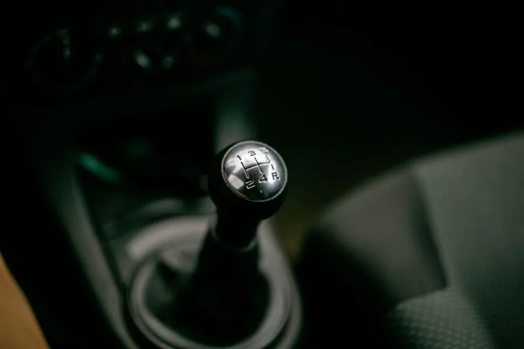 Detailed view of a manual gear shifter inside a vehicle, with a focus on the gear shift knob.