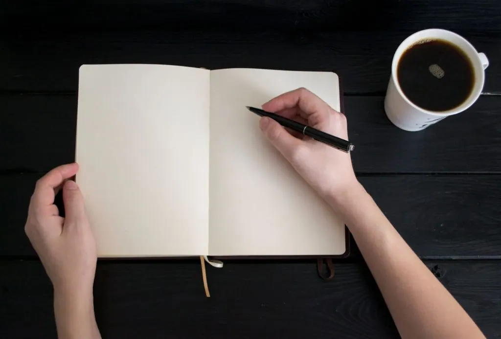 Empty notebook with a pen and coffee cup, perfect for writing inspiration concepts.