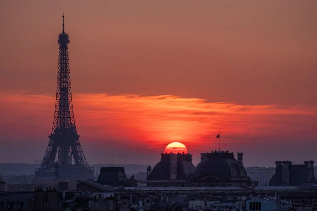 Experience the breathtaking sunset over Paris with the iconic Eiffel Tower silhouette.