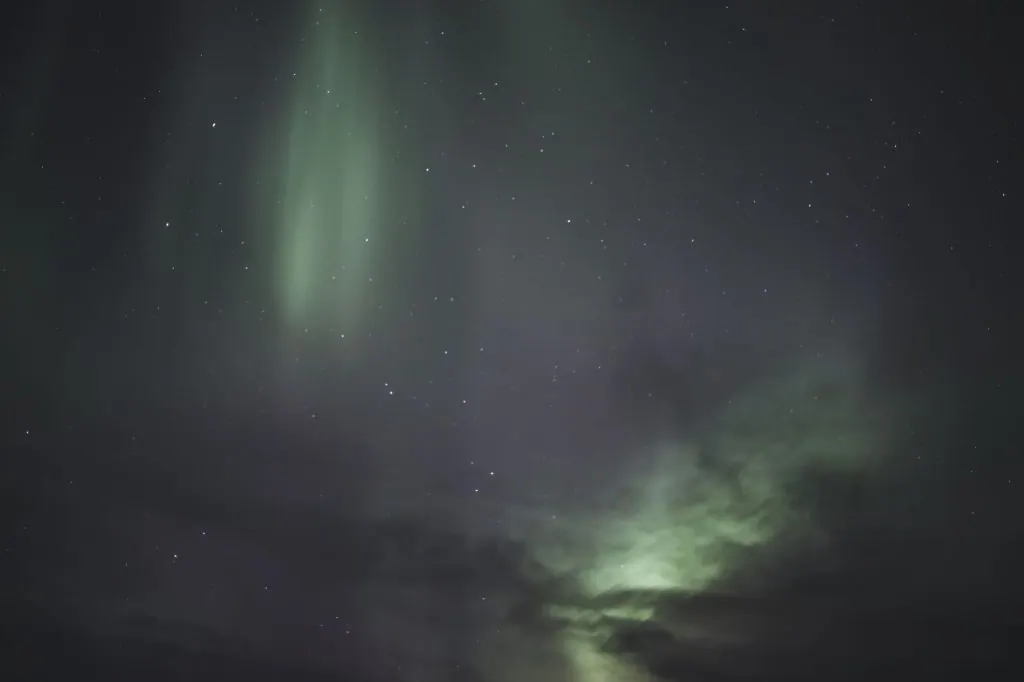 Capture the breathtaking Northern Lights dancing over Iceland's serene night landscape.