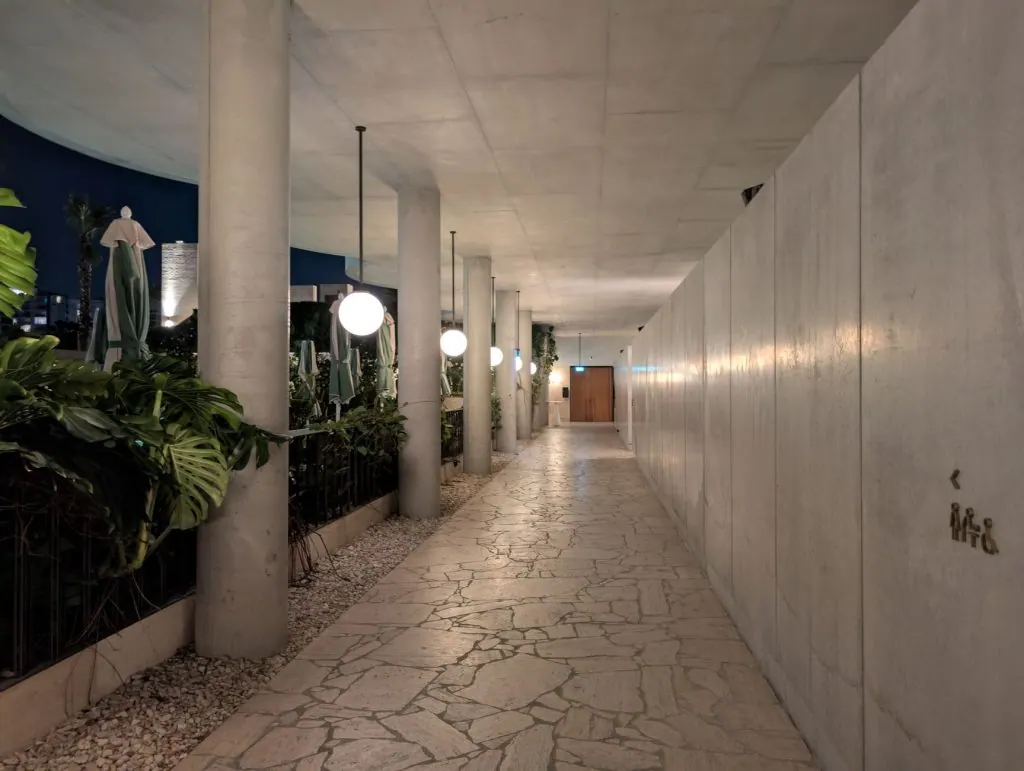 Long corridor in Fortitude Valley with modern lights and plants at night.