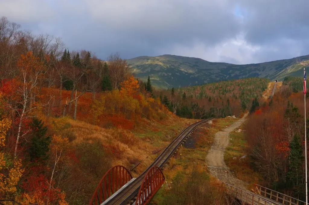 Railroad cutting through vibrant autumnal hills in New Hampshire, USA.
