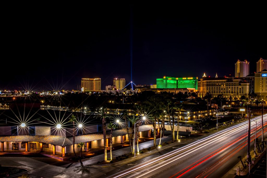 Dynamic night view of Las Vegas Strip with glowing hotels and bustling light trails.
