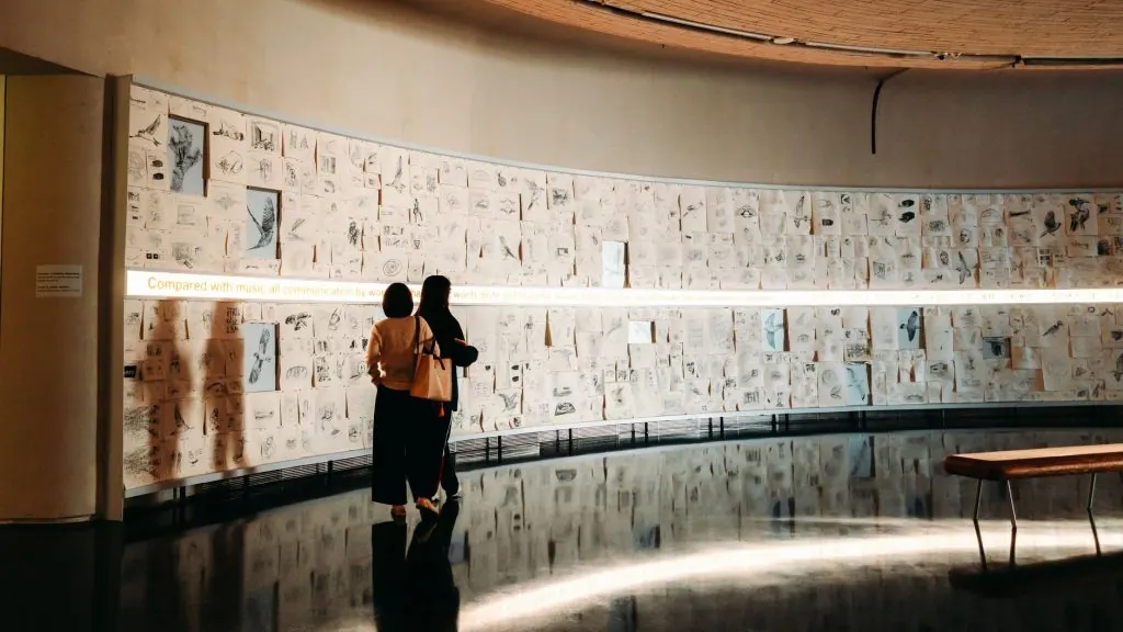 Two people viewing sketches in a modern art gallery. Warm lighting sets an intimate tone.