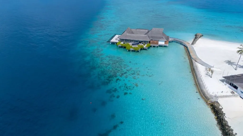 A stunning aerial view of a tropical resort on the turquoise waters of the Maldives.