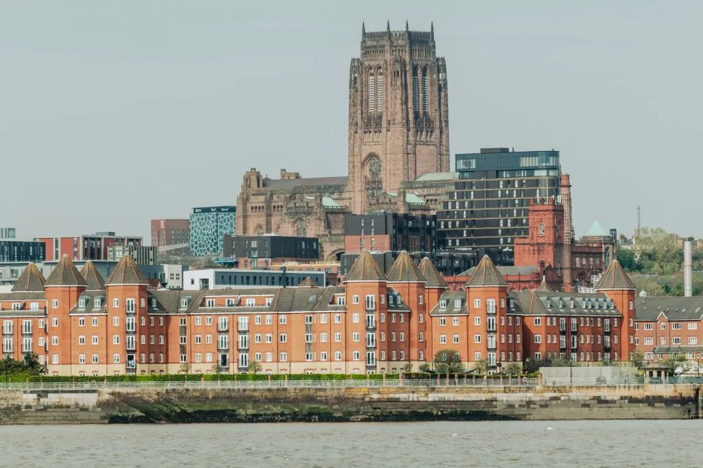 Scenic view of Liverpool Cathedral with surrounding buildings by the riverside.