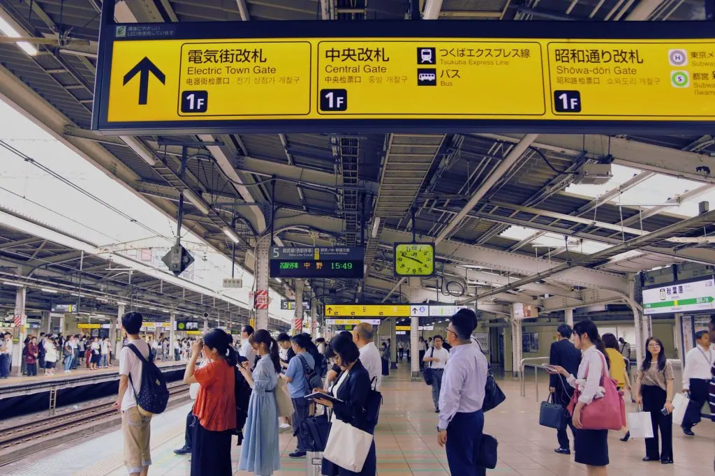 Commuters at a bustling train station in Tokyo, Japan, waiting for their train.