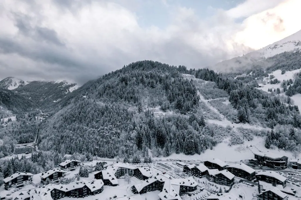 Aerial view of snow-covered Les Contamines-Montjoie village and surrounding mountains.